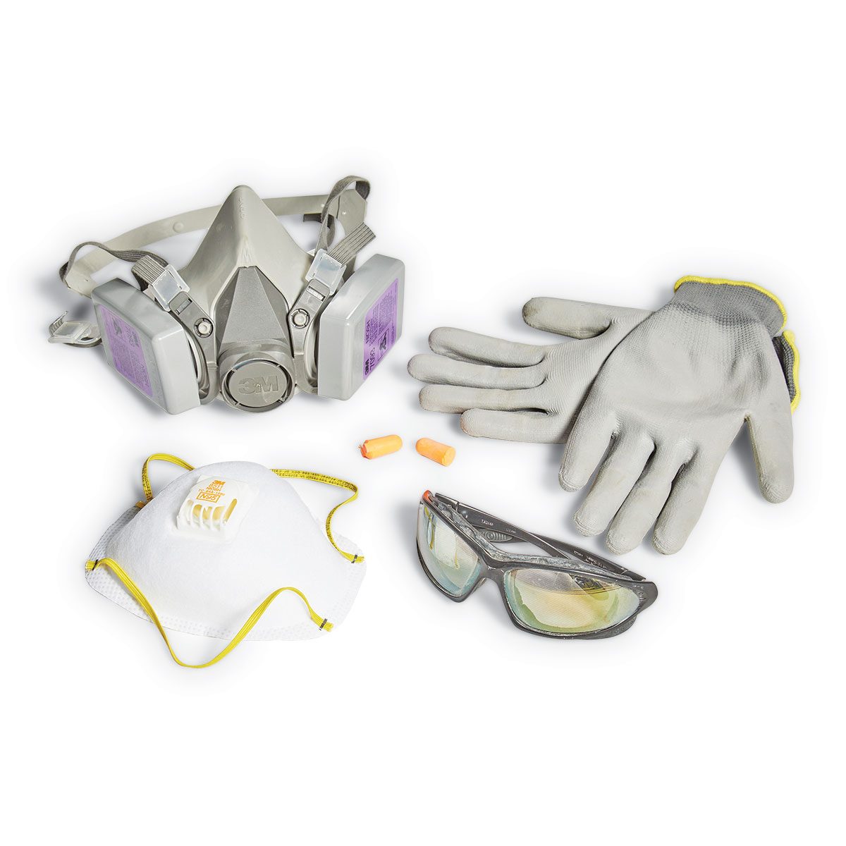 A set of personal protective equipment, including a respirator, face mask, gloves, and safety glasses, arranged on a plain background, prepared for use.