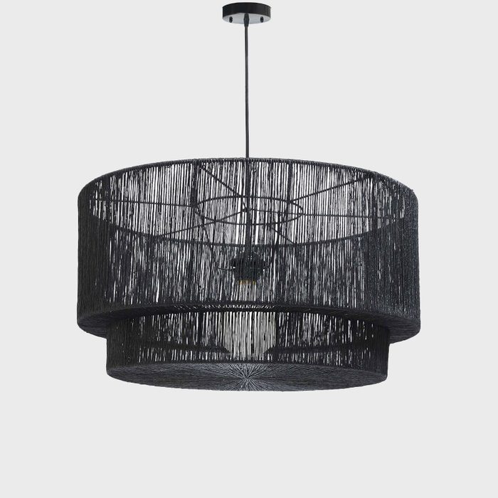 A black pendant lamp hangs from the ceiling, casting light through its layered, fringed design, enhancing the ambiance of a modern interior space.