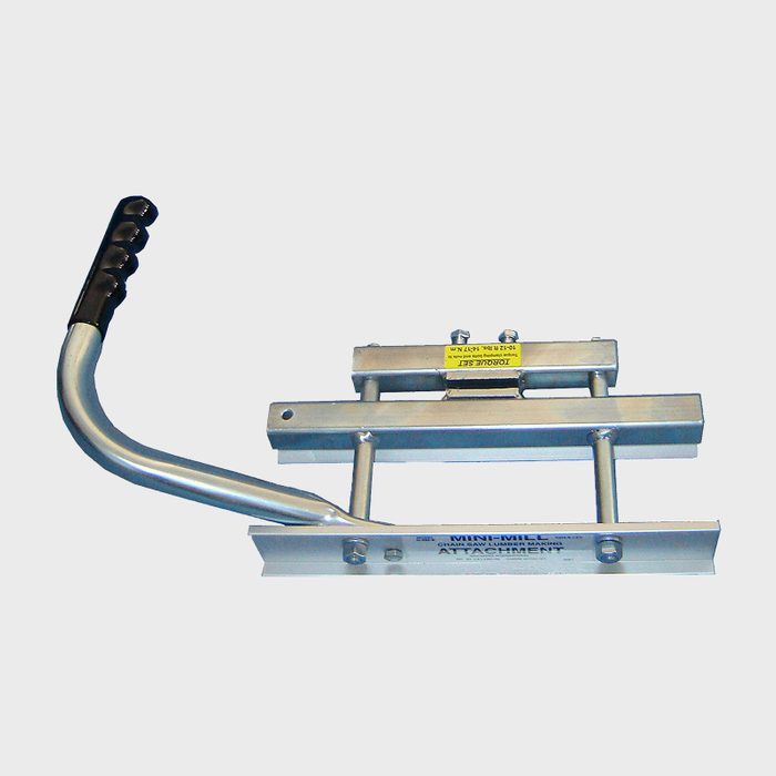 A metal attachment with a curved handle is positioned for operation, designed for use with milling equipment, typically in a workshop or industrial setting.