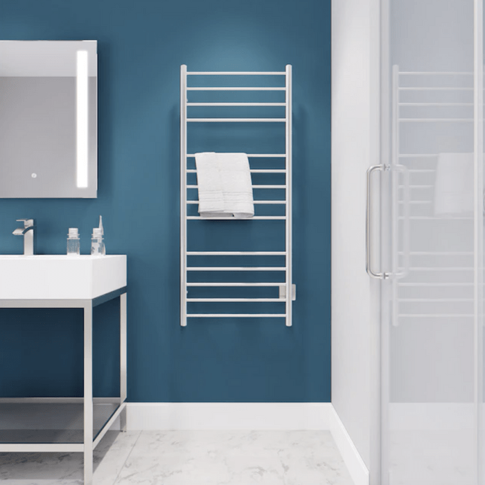 A white towel rack holds a folded towel while a sleek sink with glass bottles sits nearby, all against a blue wall in a modern bathroom.