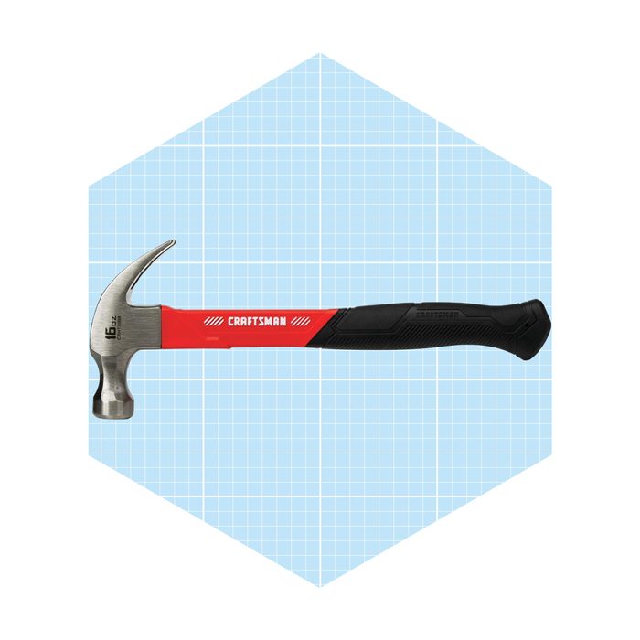 A metal hammer rests horizontally, showcasing a red and black handle against a light blue grid background, emphasizing its sleek design and practical use.