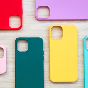 Cases set for smartphone on wooden background. Silicone protection for mobile phone. Colorful silicone phone cases.